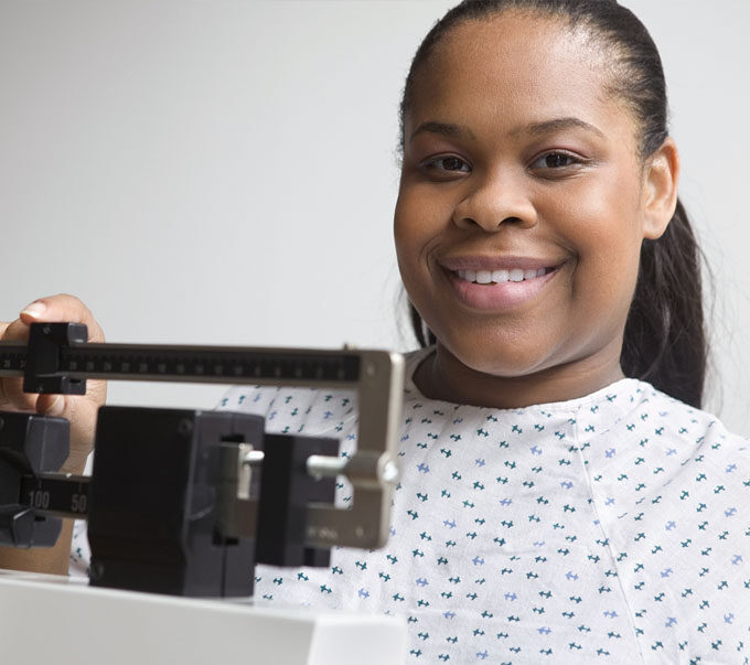 woman standing on scale and smiling